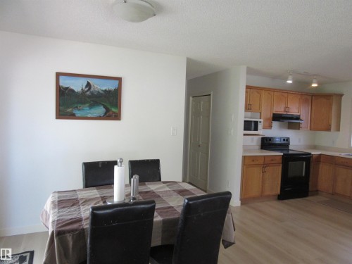 Kitchen featuring wood cabinetry, white countertops, black range, and white microwave - 64 Heatherglen Close, Spruce Grove, AB 