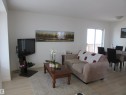 Open-concept living area with light wood-finish flooring, white walls, and a sliding glass door leading to an outdoor deck - 64 Heatherglen Close, Spruce Grove, AB 