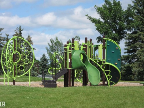 Recreational playground equipment featuring a slide, climbing wall, and circular climbing structure - 64 Heatherglen Close, Spruce Grove, AB 