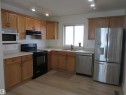 Kitchen featuring light wood cabinetry, light-toned countertops, and wood-finish flooring - 64 Heatherglen Close, Spruce Grove, AB 