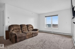 Bright living space featuring neutral carpeting and white walls - 