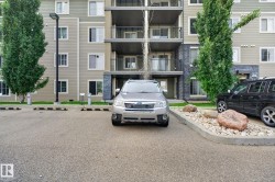 Exterior of a multi-story building featuring balconies with metal railings, a stone facade accent, and light-colored siding - 