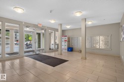 Lobby entrance featuring large format tile flooring, multiple flush-mount ceiling lights, and an array of individual mailboxes - 