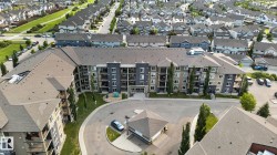 Multi-story building featuring balconies, a central entrance, and a surrounding paved drive - 