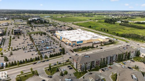 Aerial perspective showcasing a multi-story residential building with private balconies and surface parking - 415 111 Watt Common, Edmonton, AB 