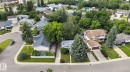 Aerial perspective showcasing a residential neighborhood with diverse architectural styles, mature trees, and varied landscaping - 4712 131 Avenue Nw, Edmonton, AB 