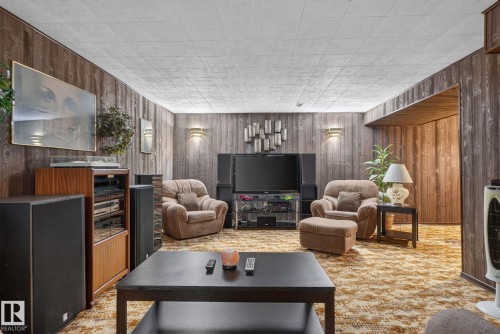Recreation room featuring wood-finish wall paneling and acoustic tile ceiling - 4712 131 Avenue Nw, Edmonton, AB 