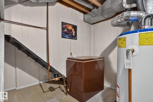 Utility area featuring a water heater, exposed ductwork, and a staircase with open risers - 4712 131 Avenue Nw, Edmonton, AB 