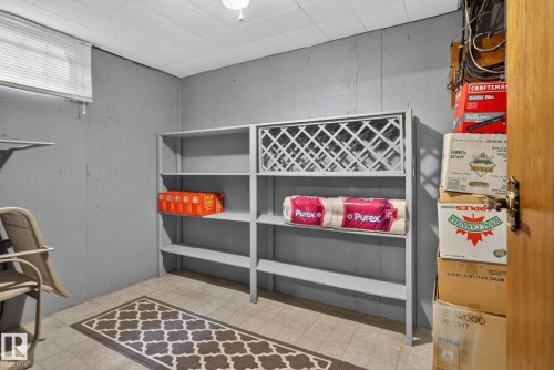 Utility area featuring built-in shelving, tile flooring, and textured wall finishes - 4712 131 Avenue Nw, Edmonton, AB 