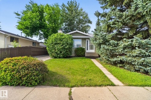 Single-story home featuring a light green exterior siding and a front lawn - 4712 131 Avenue Nw, Edmonton, AB 