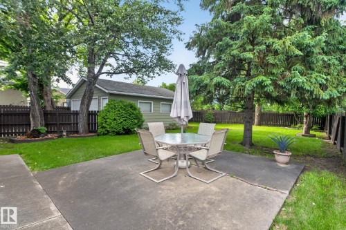 Expansive concrete patio area surrounded by a manicured lawn - 4712 131 Avenue Nw, Edmonton, AB 