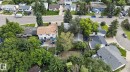 Aerial view showcasing a residential property with a brown shingle roof, mature trees, and a spacious backyard - 4712 131 Avenue Nw, Edmonton, AB 
