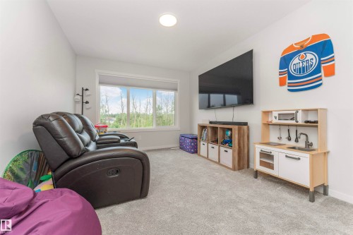 Carpeted room with a large window offering natural scenery - 102 Horton Way, Ardrossan, AB 