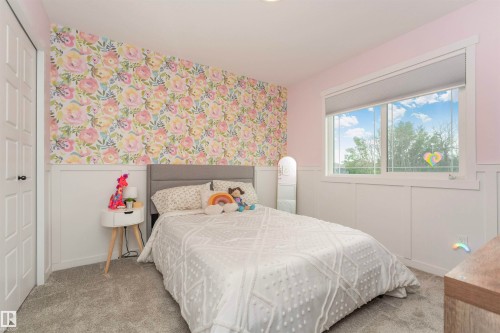 Room featuring a floral accent wall, white wainscoting, and gray carpeting - 102 Horton Way, Ardrossan, AB 