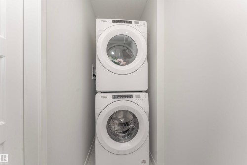 Dedicated laundry closet with stacked, front-loading washer and dryer units - 102 Horton Way, Ardrossan, AB 