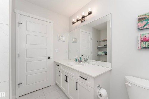 Bathroom vanity featuring a white countertop, undermount sink, and dark bronze faucet - 102 Horton Way, Ardrossan, AB 