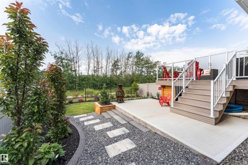 Multi-level outdoor living space featuring a composite deck with glass panel railings and a concrete patio - 102 Horton Way, Ardrossan, AB 