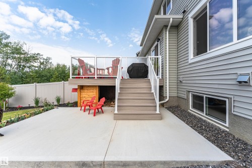 Rear exterior featuring a multi-level deck with glass panel railing and composite decking - 102 Horton Way, Ardrossan, AB 