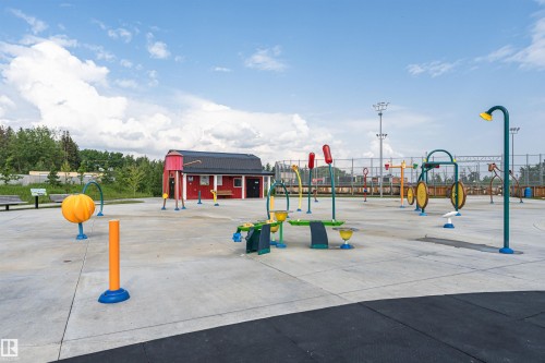 Expansive splash pad featuring various water play structures on a concrete surface - 102 Horton Way, Ardrossan, AB 