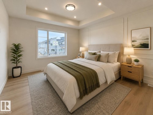 Bedroom featuring a tray ceiling with recessed lighting, a large window, light wood-finish flooring, and decorative wall paneling - 115 Pierwyck Loop, Spruce Grove, AB 