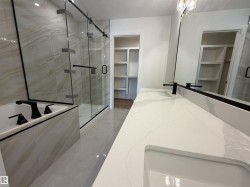 Dual vanity with integrated sinks and white countertops, featuring matte black faucets and a large wall-mounted mirror - 