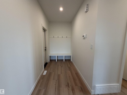 Entryway featuring wood-finish flooring, recessed lighting, and a built-in bench with storage and coat hooks - 115 Pierwyck Loop, Spruce Grove, AB 