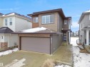 Modern two-story residence with a multi-toned facade, featuring a large attached garage, a blue entry door, and prominent windows on the upper level - 19066 20A Avenue, Edmonton, AB 