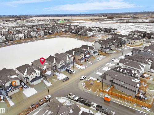 Aerial view of a residential community featuring a frozen pond - 19066 20A Avenue, Edmonton, AB 