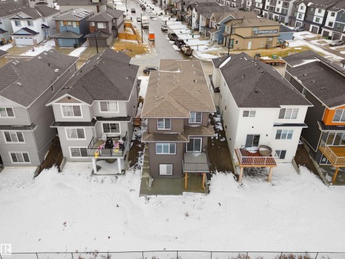 Modern multi-level residence featuring a gray exterior, dark shingle roof, and a ground-level patio - 19066 20A Avenue, Edmonton, AB 