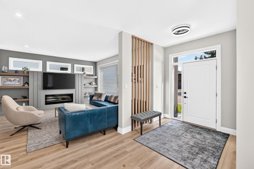 Entryway with wood-finish flooring and a contemporary front door with sidelight - 12631 52 Avenue, Edmonton, AB 