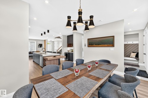 Spacious dining area featuring a contemporary chandelier, wood-finish flooring, recessed lighting, and an open concept layout - 12631 52 Avenue, Edmonton, AB 