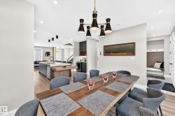 Spacious dining area featuring a contemporary chandelier, wood-finish flooring, recessed lighting, and an open concept layout - 