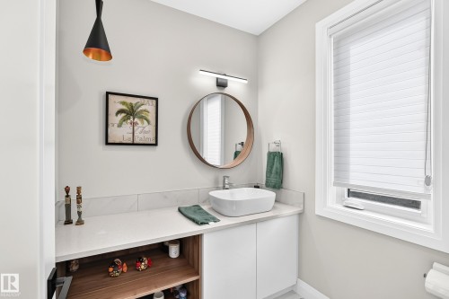 Modern vanity featuring a vessel sink, quartz countertop, and integrated wood-finish shelving - 12631 52 Avenue, Edmonton, AB 
