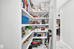 Walk-in pantry featuring abundant white shelving for organized storage - 
