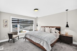 Spacious room featuring a large window with privacy blinds, plush carpet flooring, and a contemporary ceiling light fixture - 