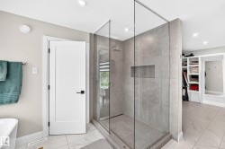 Sleek glass-enclosed shower with full-height tile surround and integrated shower niche - 