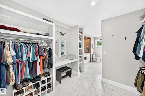 Walk-in closet featuring white built-in shelving, hanging rods, and integrated shoe storage - 12631 52 Avenue, Edmonton, AB 