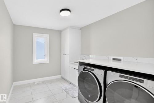 Dedicated laundry room featuring light gray walls, a single window with white trim, and white tile flooring - 12631 52 Avenue, Edmonton, AB 