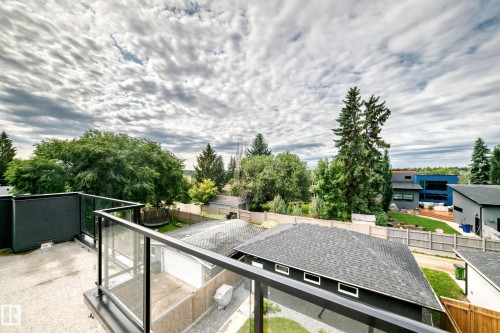 Rooftop patio featuring glass panel railings and a dark grey privacy wall - 12631 52 Avenue, Edmonton, AB 