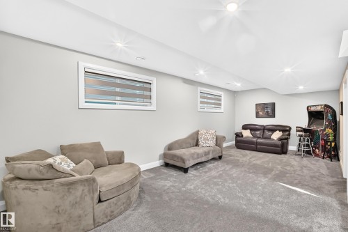 Spacious finished room featuring light gray walls, recessed lighting, and gray carpeting - 12631 52 Avenue, Edmonton, AB 
