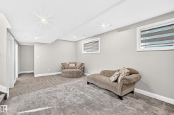 Spacious room featuring light gray wall paint, recessed lighting, white baseboards, and two windows with horizontal blinds - 