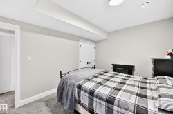 Bedroom featuring light gray wall paint, gray carpeting, a white baseboard trim, a white interior door, and a recessed ceiling light - 