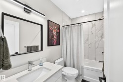 Contemporary bathroom featuring a vanity with an integrated rectangular sink, chrome single-handle faucet, and black framed mirror - 