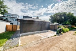 Detached two-car garage with dark siding and a concrete driveway - 