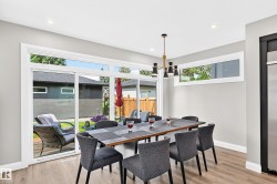 Dining area featuring wood-finish flooring, a contemporary chandelier, recessed lighting, and expansive sliding glass doors - 