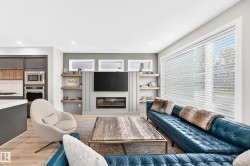 Spacious living area featuring light wood-finish flooring and recessed lighting - 