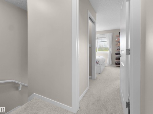 Carpeted hallway with light neutral wall paint and white trim - 49 17832 78 Street, Edmonton, AB 