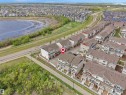 Townhouse property with a distinctive red garage door, featuring an upper-level balcony and a paved driveway - 49 17832 78 Street, Edmonton, AB 