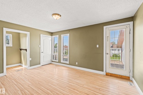 Room featuring light wood-finish flooring and olive-toned walls - 11507 141 Avenue Nw, Edmonton, AB - Indoor Photo Showing Other Room