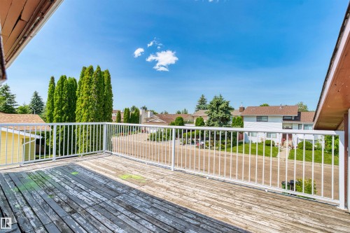 Expansive outdoor deck featuring weathered wood-finish flooring and a white metal railing - 11507 141 Avenue Nw, Edmonton, AB - Outdoor With Deck Patio Veranda With Exterior